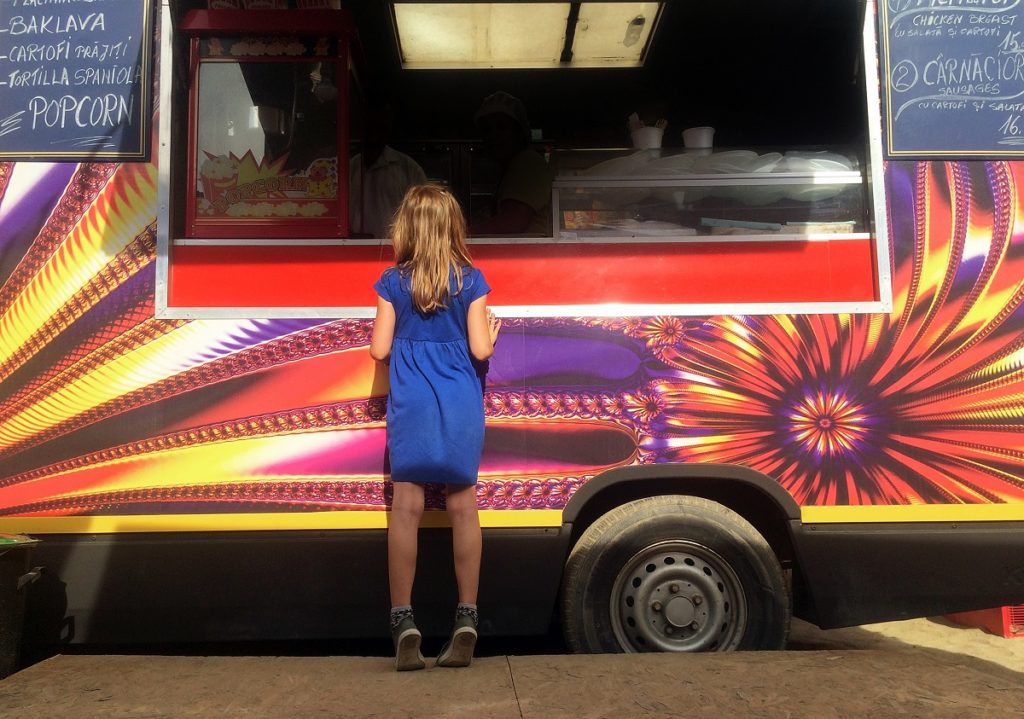 Girl standing in front of a food truck