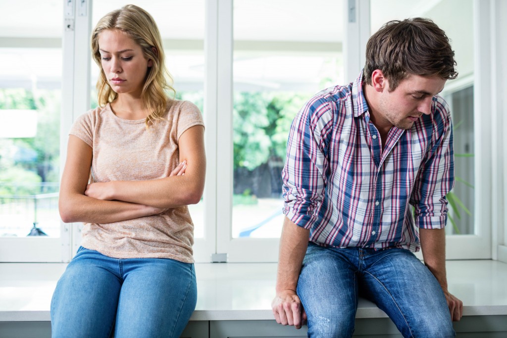 upset couple sitting opposite each other