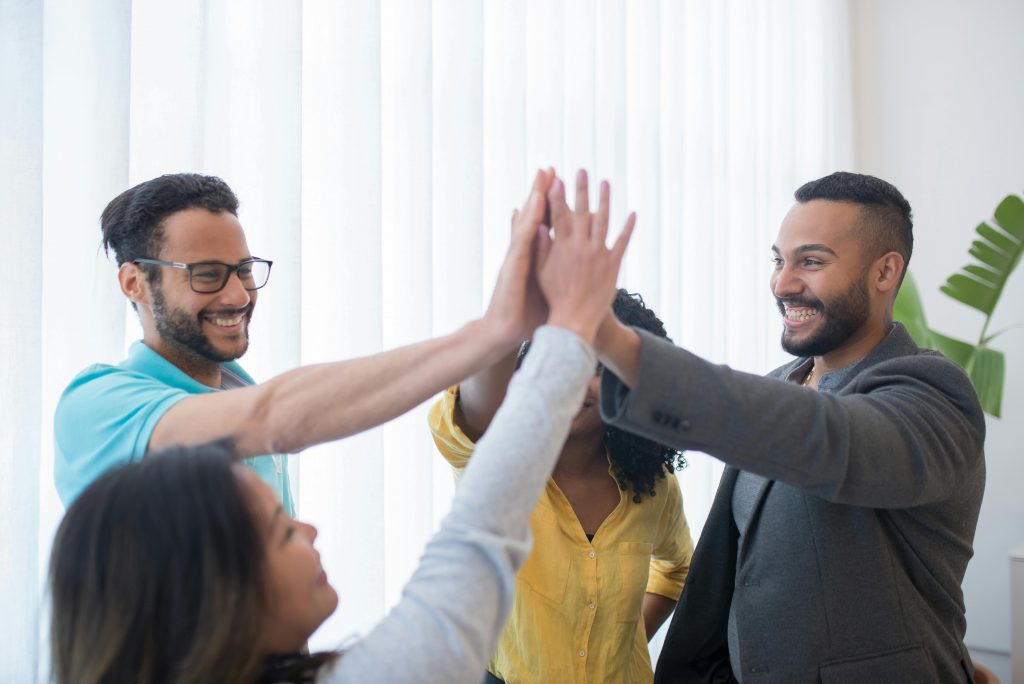 employees giving celebratory high-fives in an office