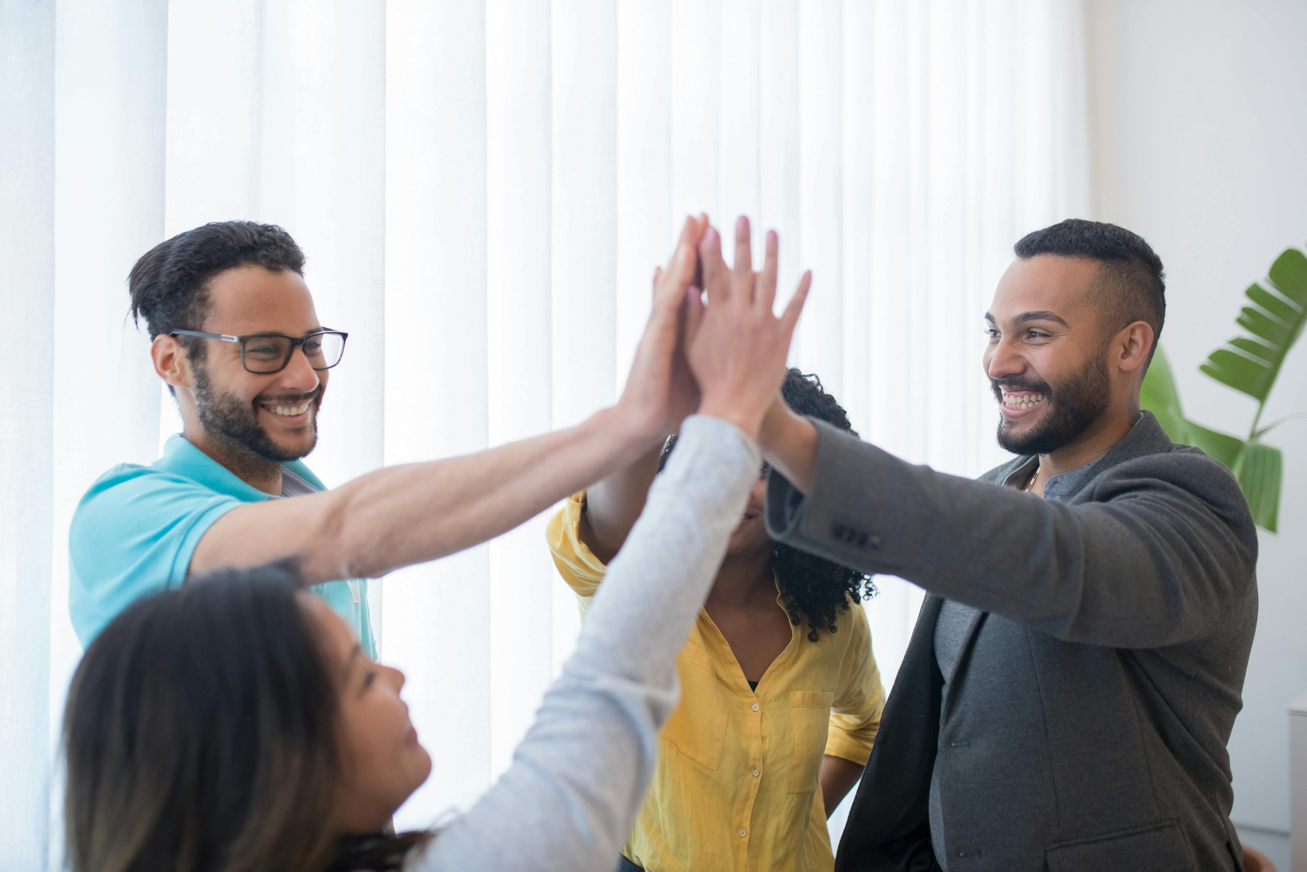 employees giving celebratory high-fives in an office