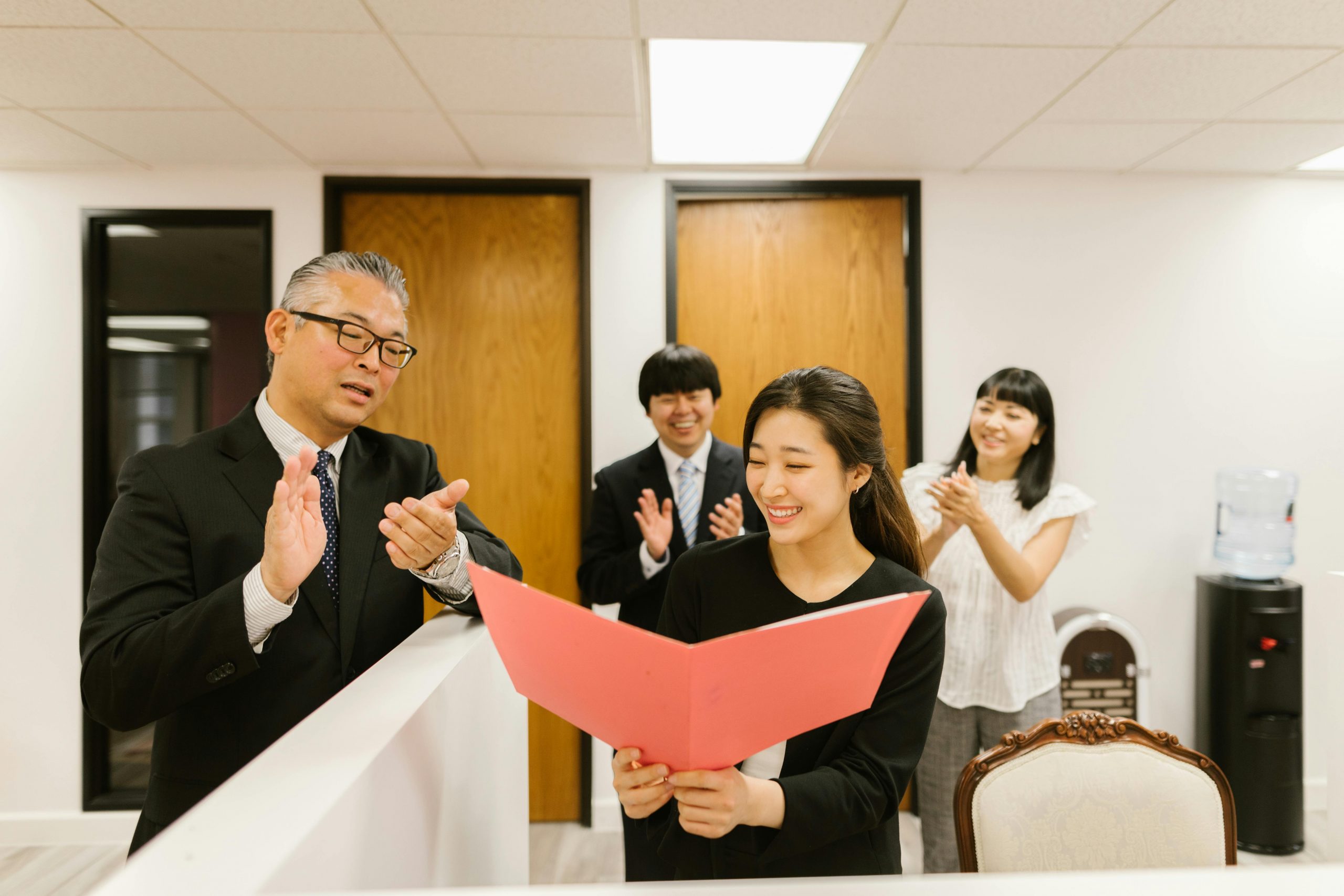 manager and colleagues clapping to recognize an employee's achievement